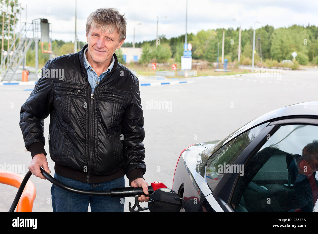 L'homme mature russe remplissant la voiture moderne avec de l'essence dans les stations-service en Russie Banque D'Images