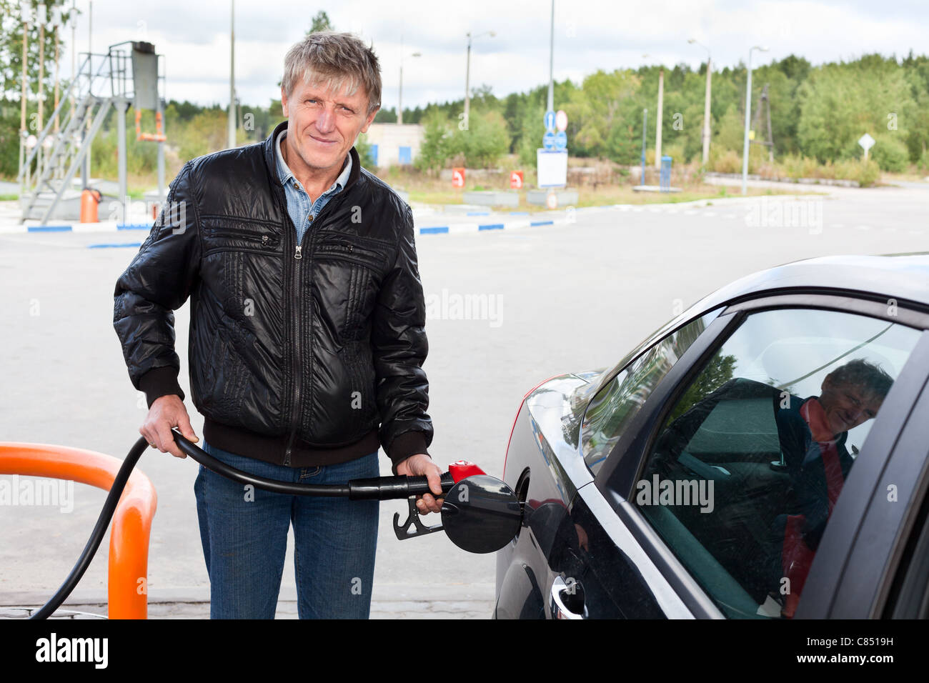 L'homme mature russe remplissant la voiture moderne avec de l'essence dans les stations-service en Russie Banque D'Images