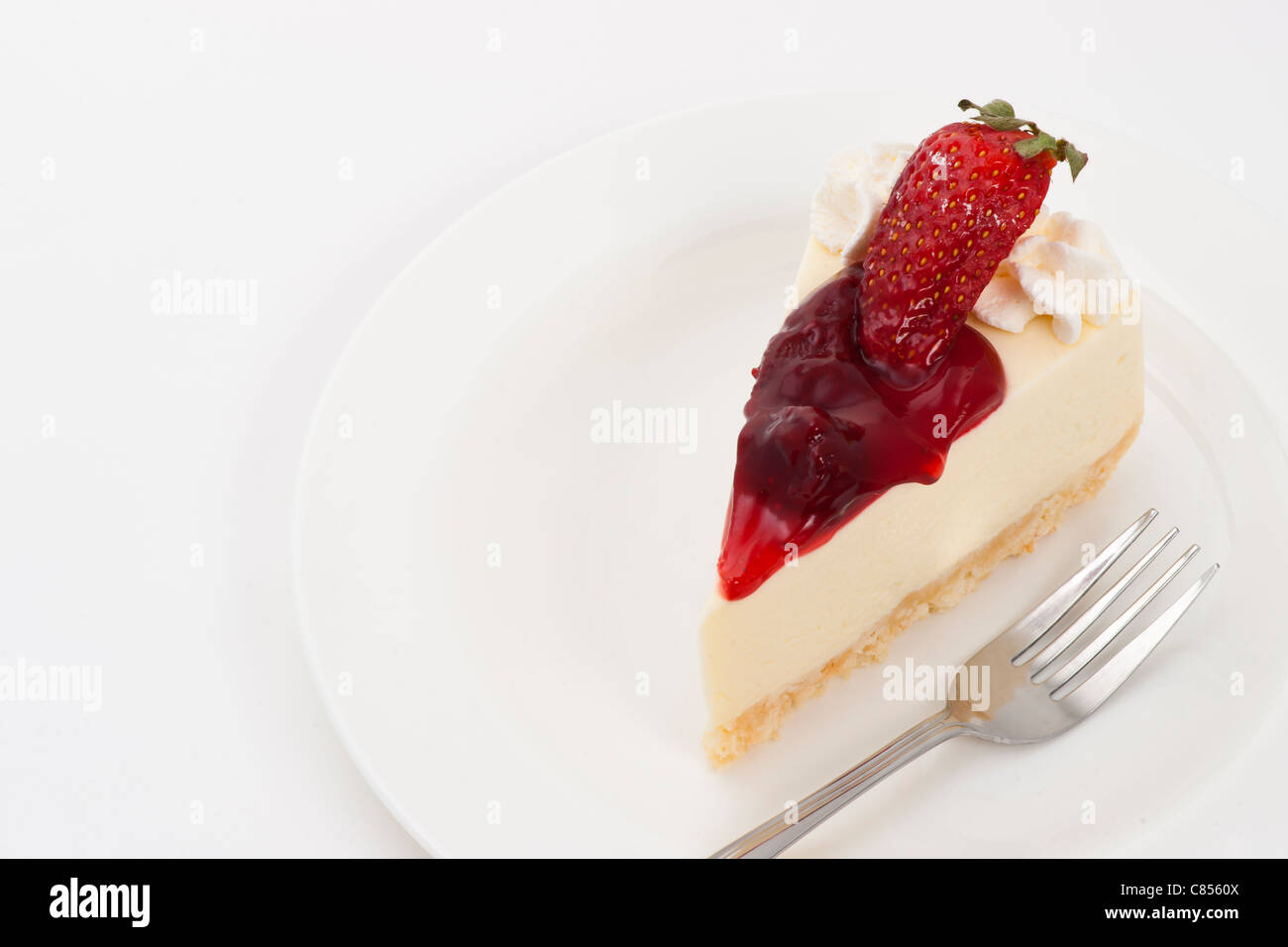 Gâteau au fromage aux fraises sur fond blanc et plaque Banque D'Images