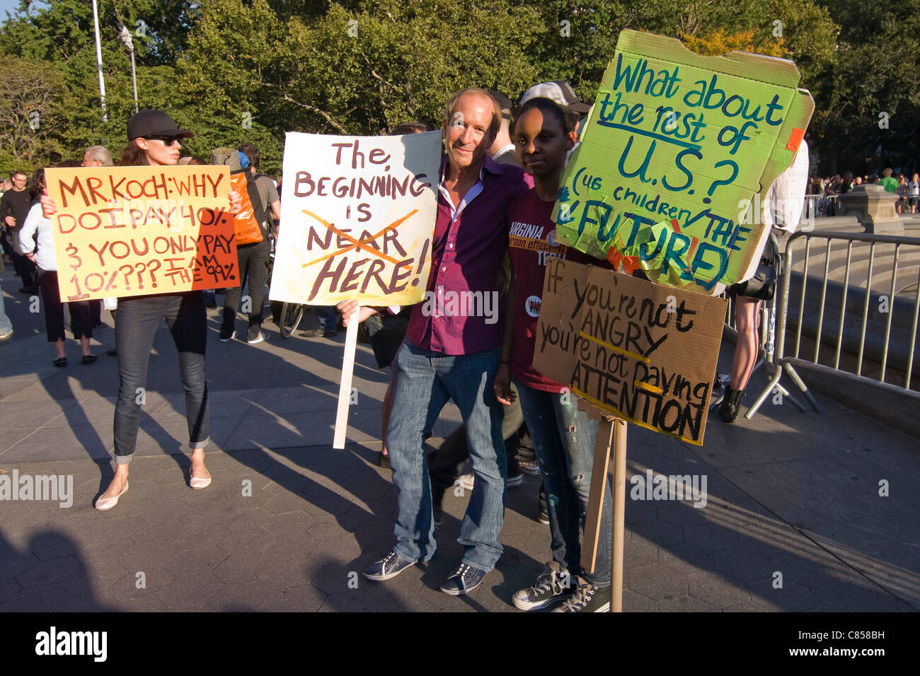 Vieux et jeunes manifestants Occupy Wall Street à Washington Square Park à New York City holding signs dans la solidarité Banque D'Images