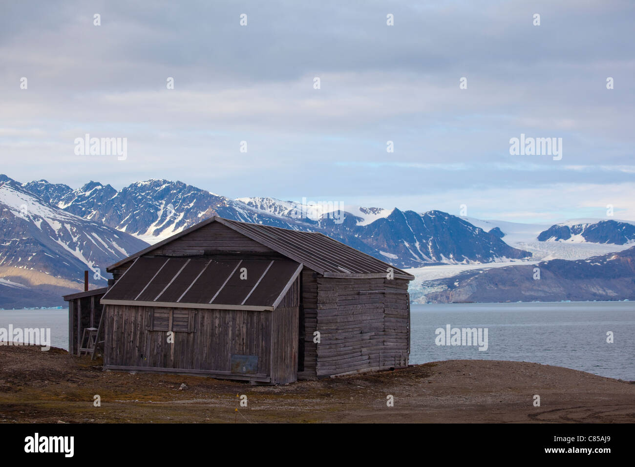 Cabane en bois Kongsfjord, avec glacier en arrière-plan sur la base de recherche scientifique internationale de Ny Alesund, Svalbard. Banque D'Images