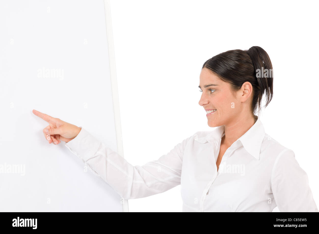 Happy businesswoman pointing at vide tableau on white Banque D'Images