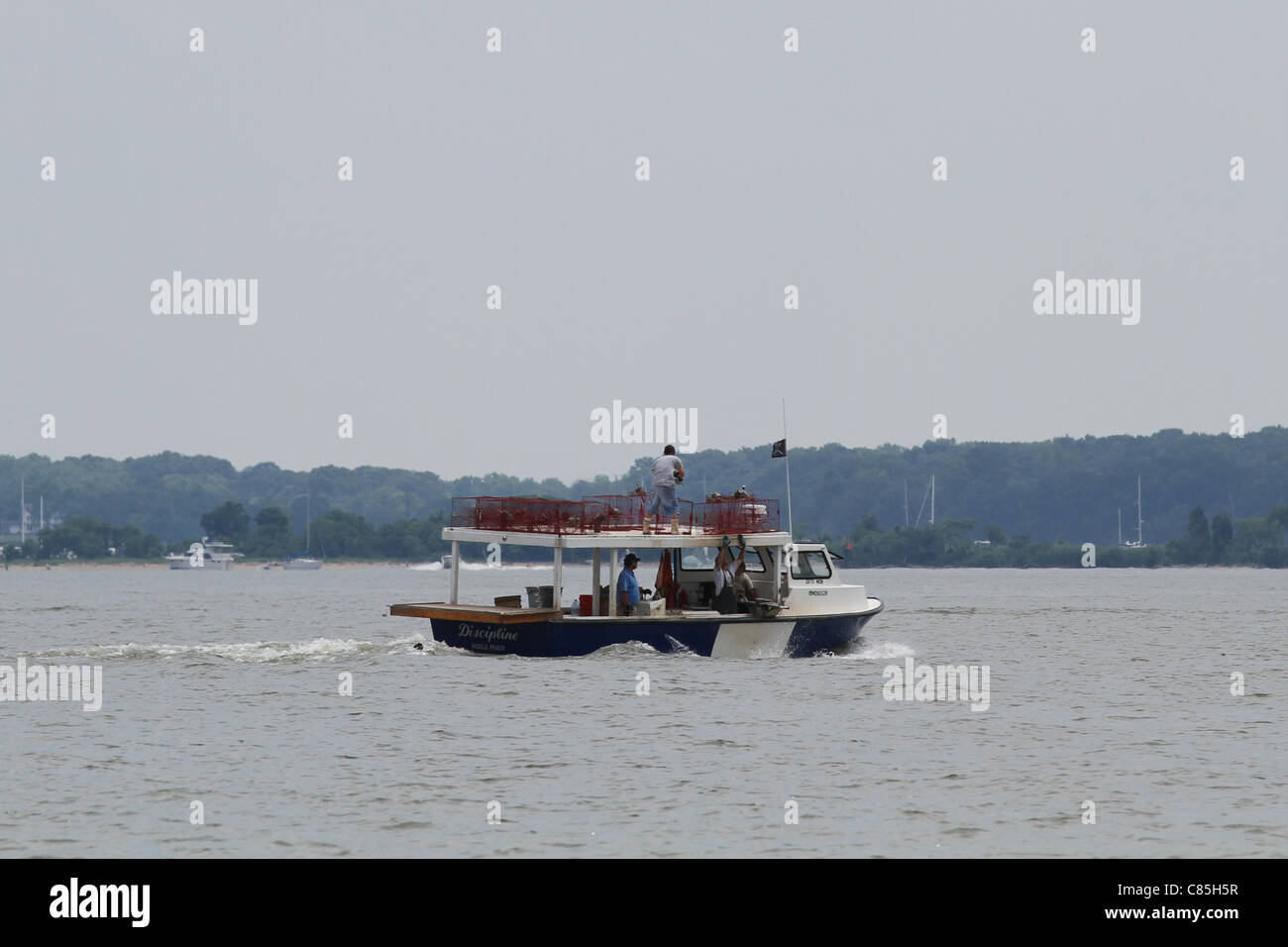 Quatre hommes dans un bateau la pose de pièges Banque D'Images