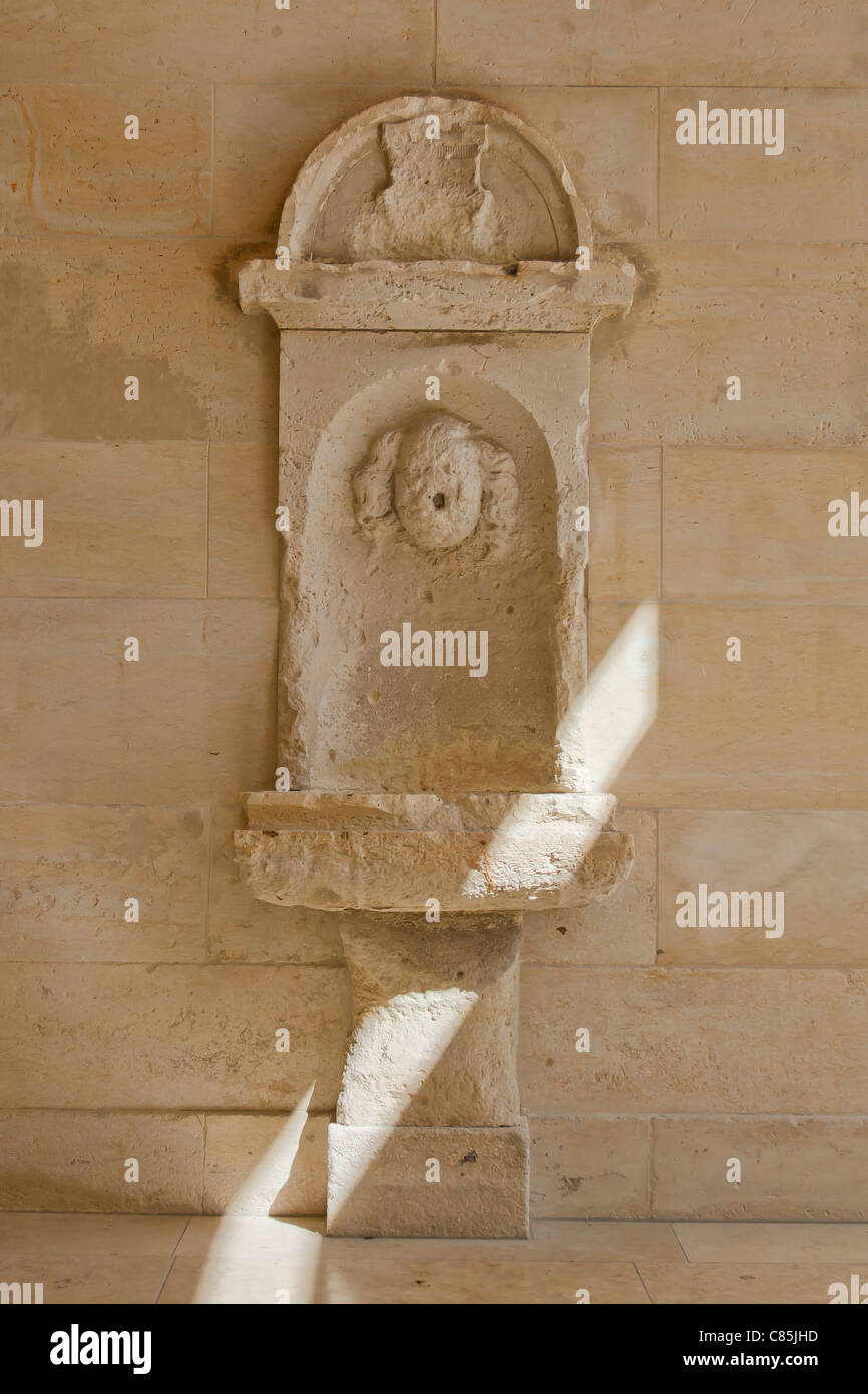 L'ordre de l'eau potable fontaine sur le mur de Neues Schloss. Bad Muskau, Allemagne. Banque D'Images