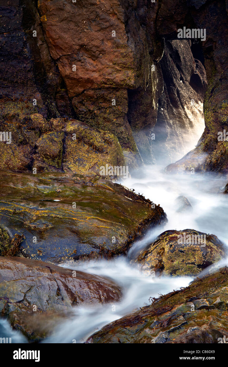 L'eau et des pierres sur les portes de l'Église, Skrinkle Haven, près de Tenby, Pembrokeshire. Banque D'Images