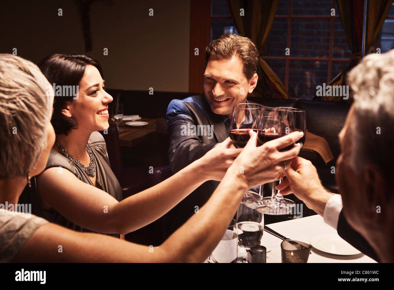 Des couples toasting with red wine in restaurant Banque D'Images