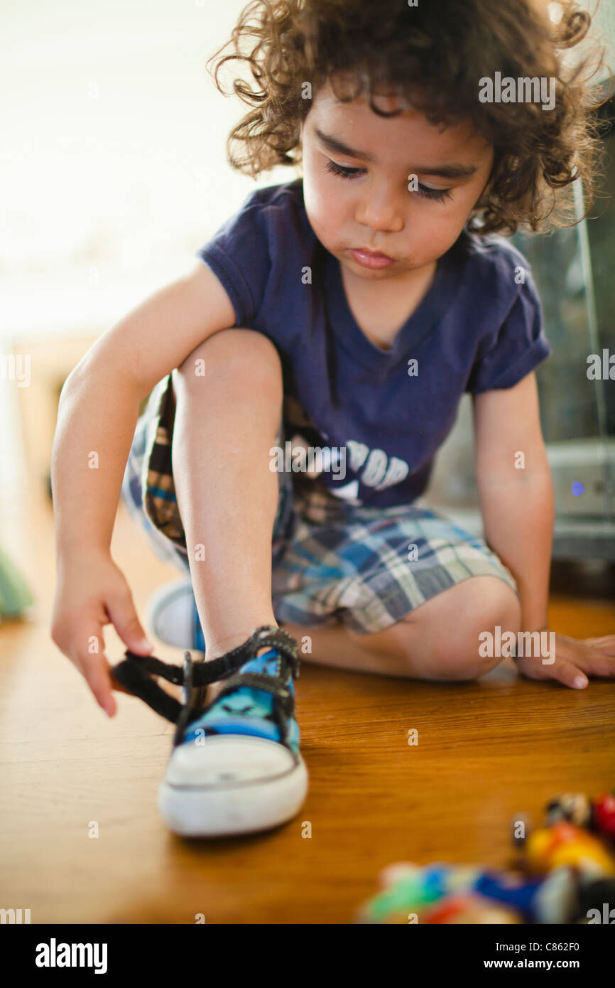 Mixed Race boy chaussures de fixation Banque D'Images