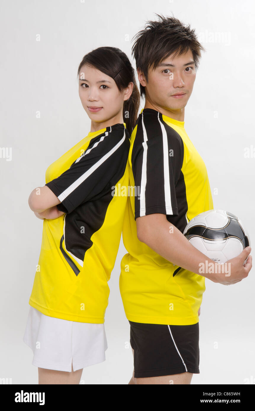 Jeune couple comme les joueurs de football Banque D'Images