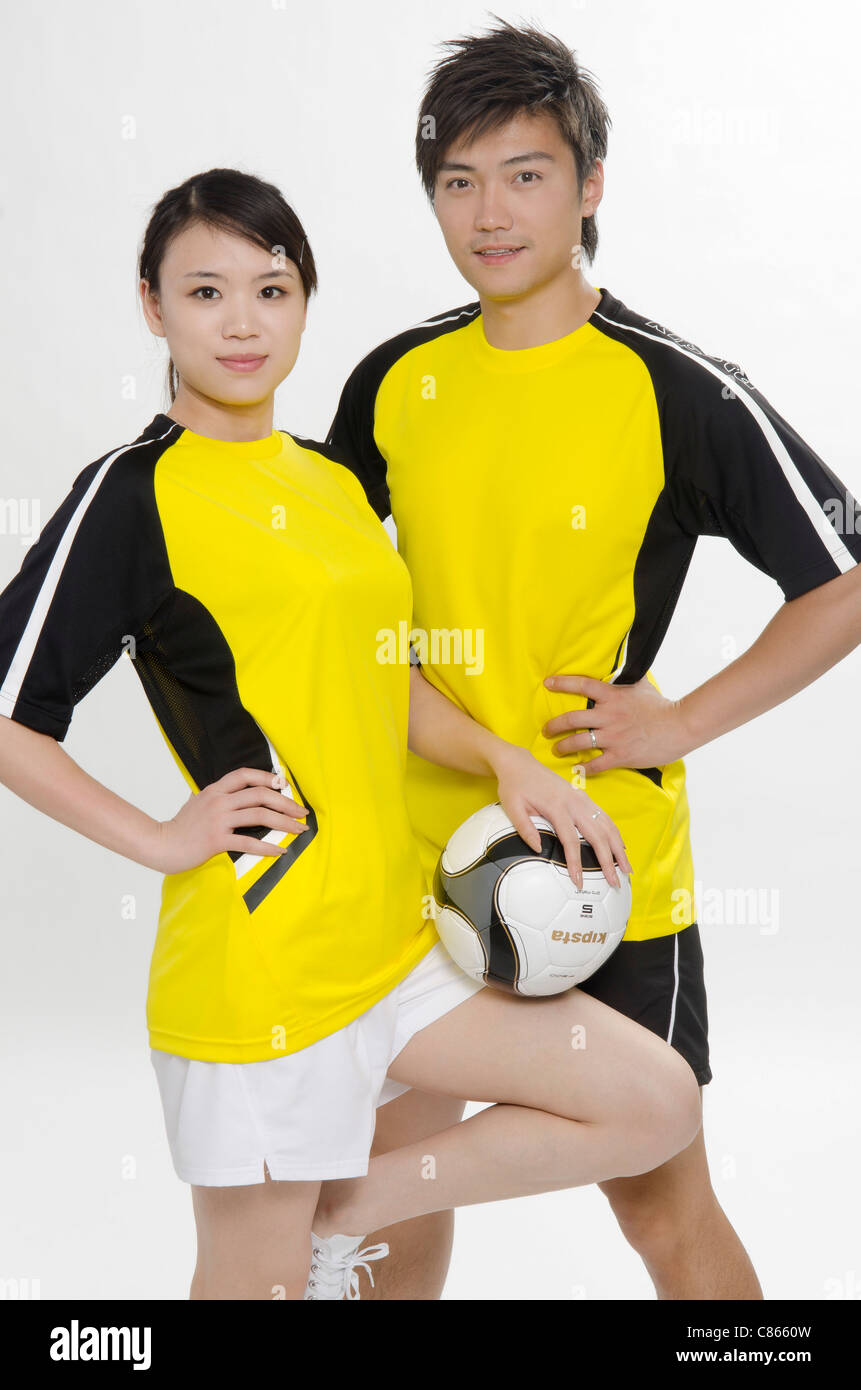 Jeune couple de joueurs de football Banque D'Images