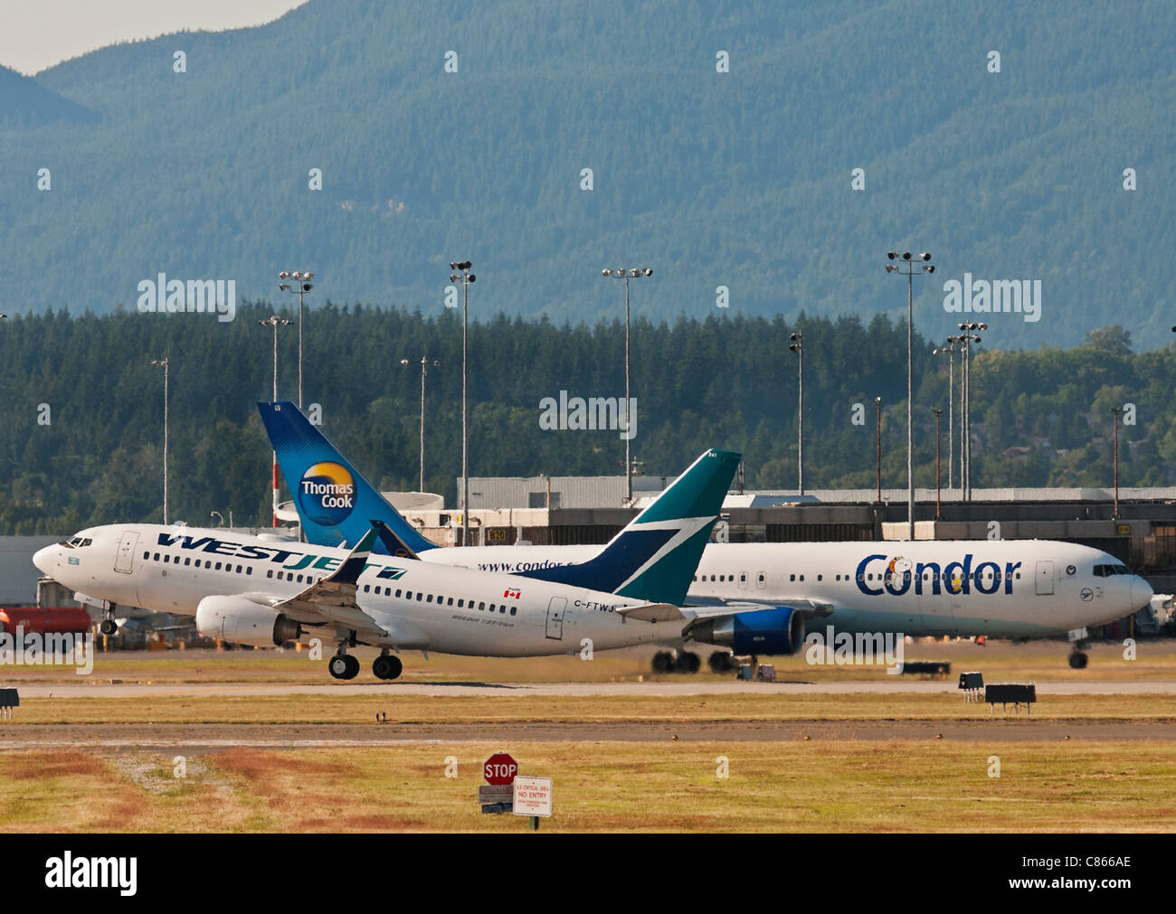 Avions : un Boeing 737 de Westjet décolle comme un Condor (Thomas Cook) Boeing 767 taxis pour poste à Vancouver (Canada) aéroport Banque D'Images
