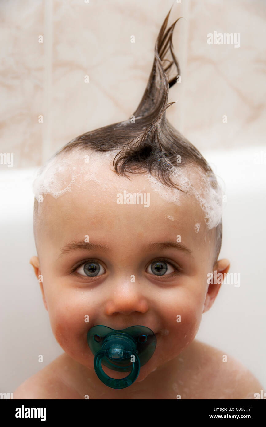 Petit garçon dans la baignoire avec les cheveux mouillés en mohawk, portrait Banque D'Images