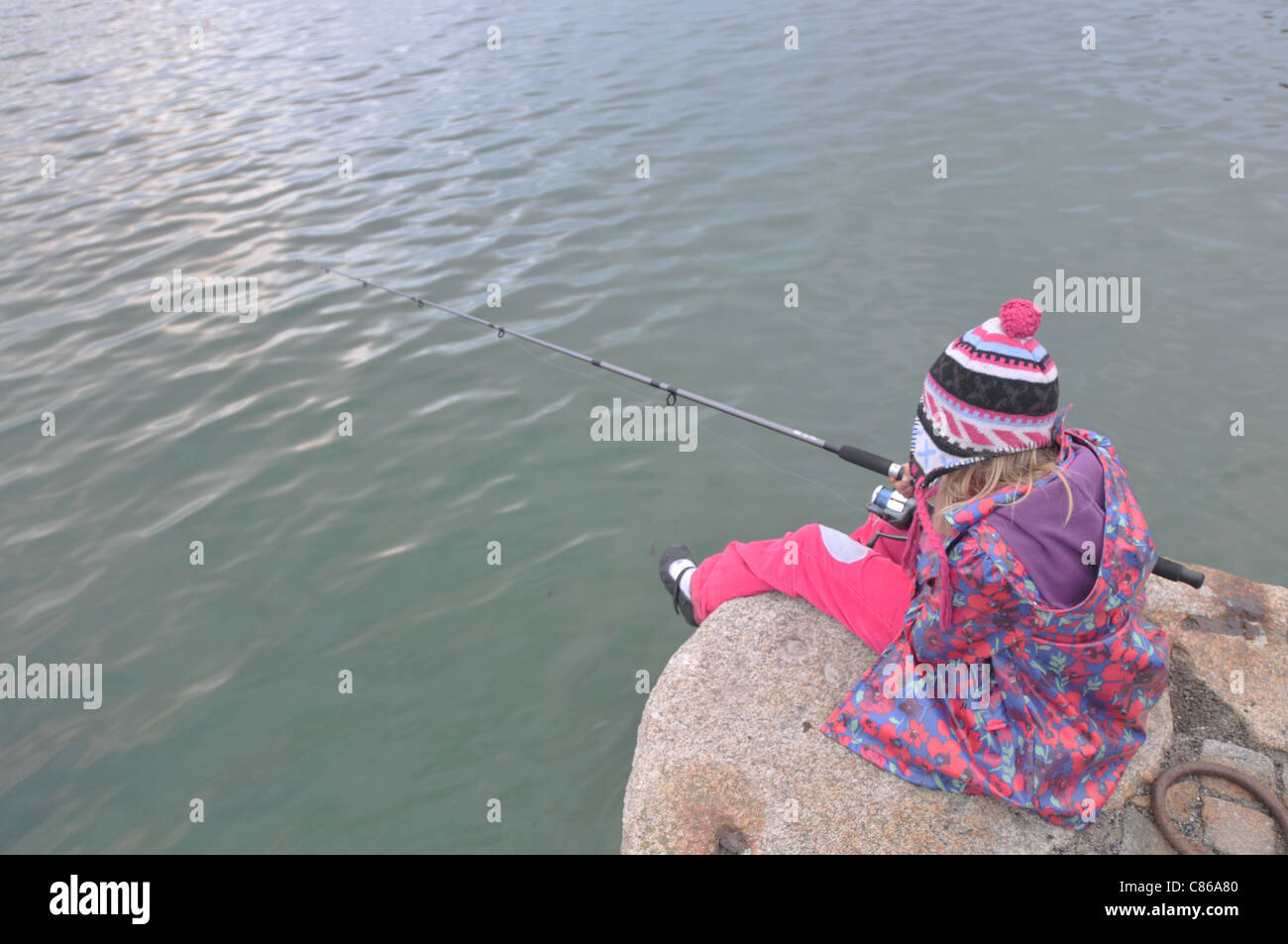 Une fillette de 8 ans la pêche dans le rinçage, Cornwall Banque D'Images