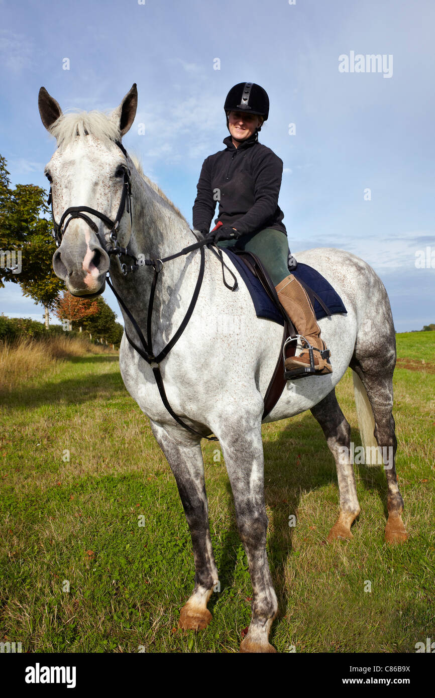Femme cheval. Un cheval gris à la traction irlandaise et une femelle dans un cadre de campagne anglaise. ROYAUME-UNI Banque D'Images