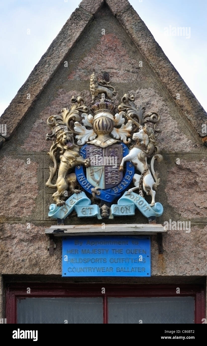 Les armoiries royales de Sa Majesté la Reine au-dessus des passants de Countrywear, Field Sports 808, rue Bridge, Ballater. Banque D'Images