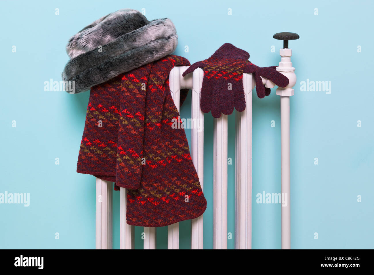 Photo d'une femme gants bonnet, écharpe et le séchage sur un vieux radiateur en fonte traditionnelle, bonne image pour l'hiver des thèmes connexes. Banque D'Images