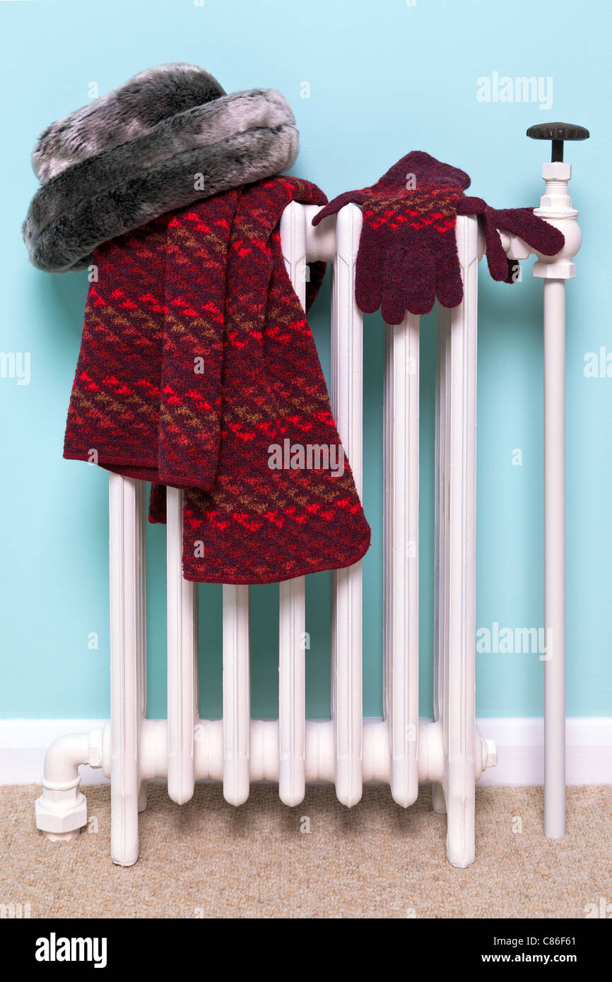 Photo d'une femme gants bonnet, écharpe et le séchage sur un vieux radiateur en fonte traditionnelle, bonne image pour l'hiver des thèmes connexes. Banque D'Images