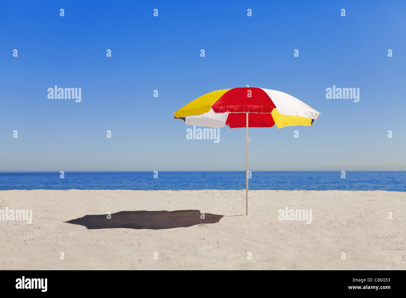 Parapluie dans le sable sur la plage vide Banque D'Images