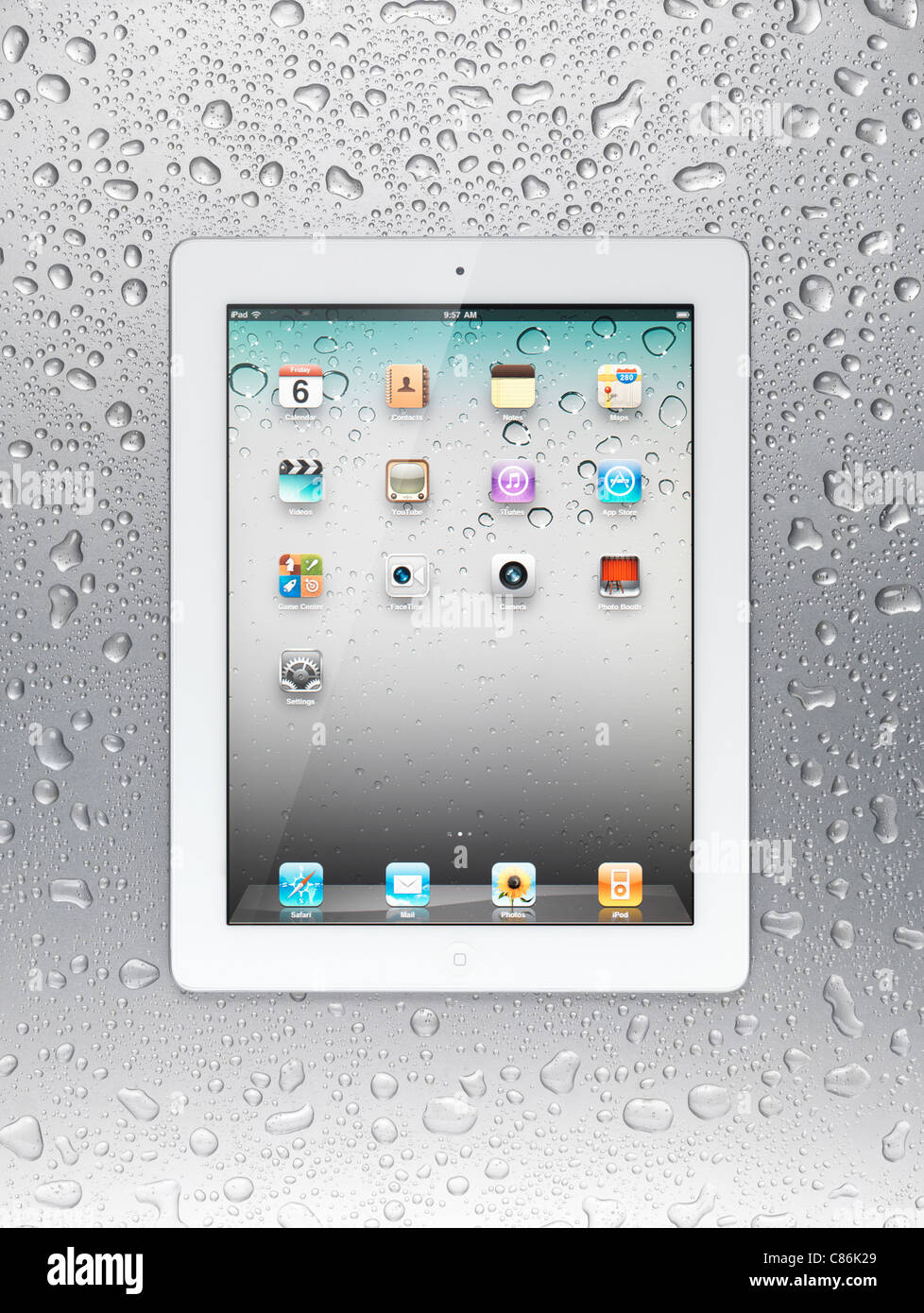 Tablette Apple iPad 2 blanc ordinateur avec des icônes du bureau sur son affichage sur fond d'acier gris humide Banque D'Images
