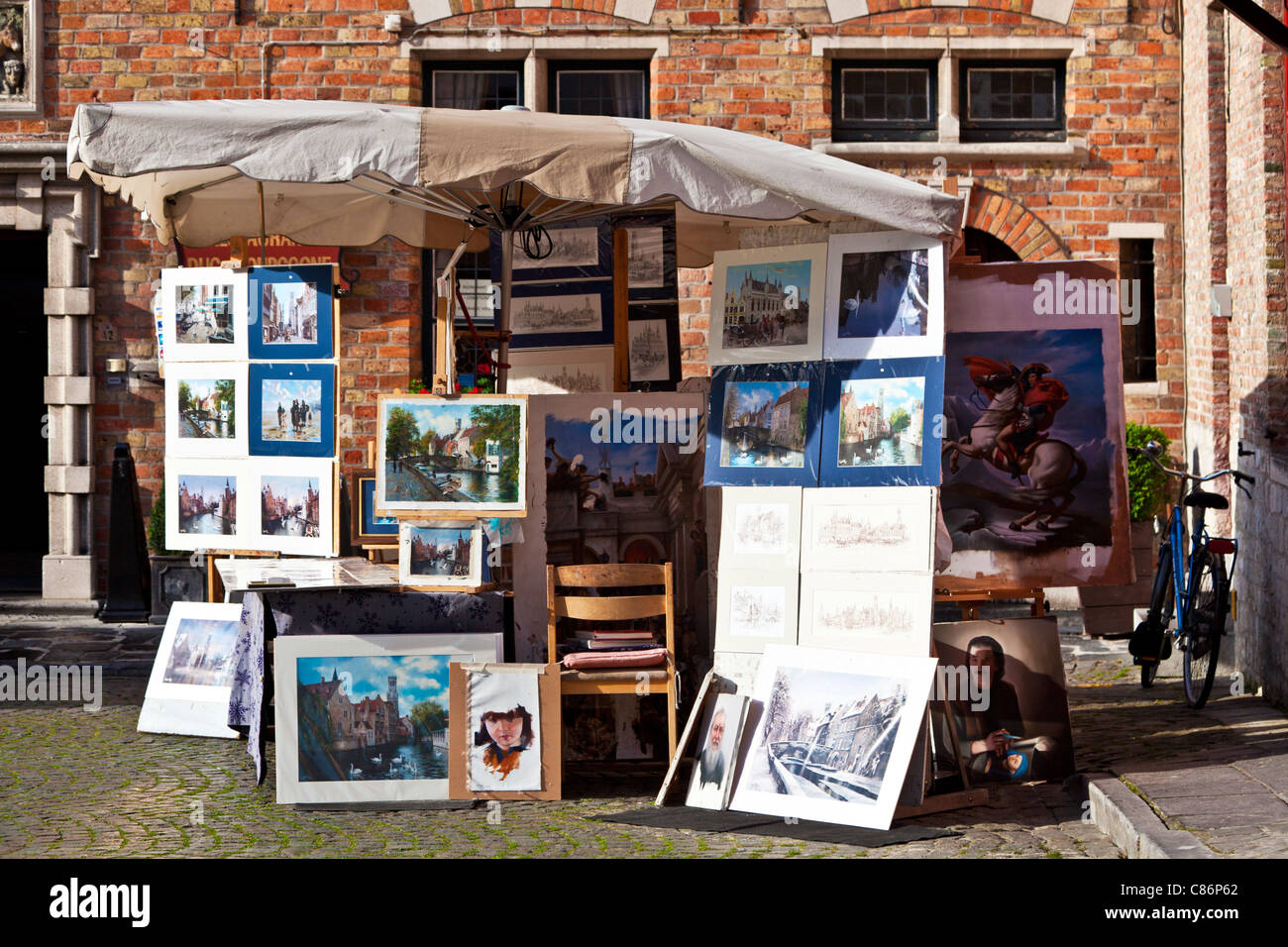 Un étal de souvenirs vendant des impressions touristiques, peintures et dessins dans la Huidenvettersplein ou la place des tanneurs, Bruges, Belgique Banque D'Images