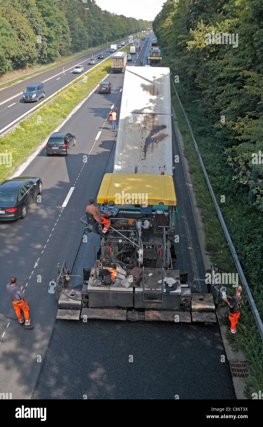 Une sous-couche de bitume appliqué par le pavé de la machine sur une route principale près de Waterloo, dans le sud de la Belgique. Banque D'Images
