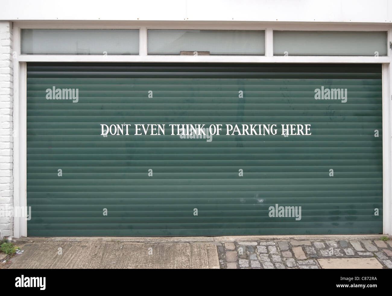 N'envisagez même pas de parking ici, un avertissement au pochoir sur une porte de garage dans le centre de Londres, Angleterre Banque D'Images