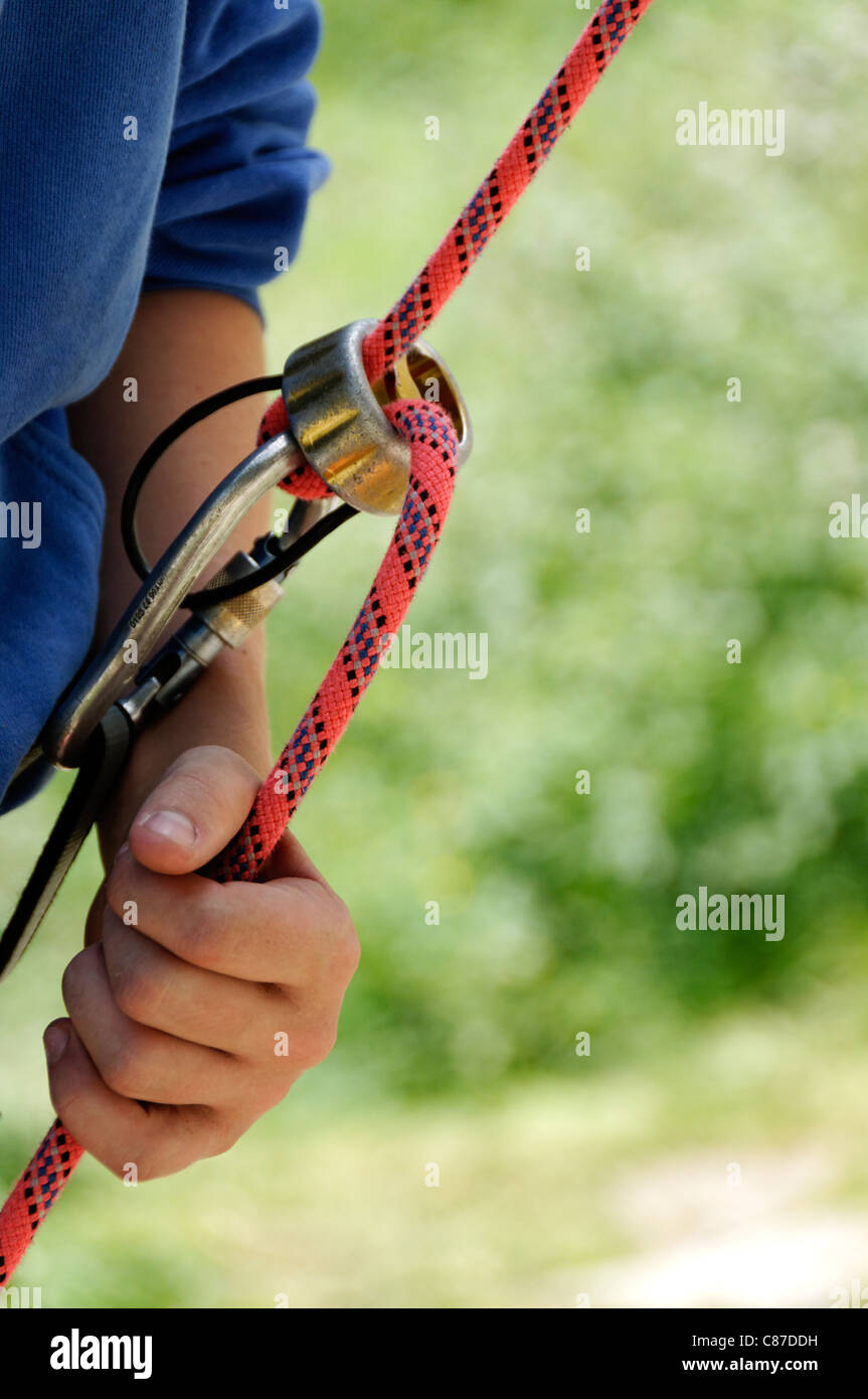Un alpiniste en utilisant une plaque d'assurage. Banque D'Images