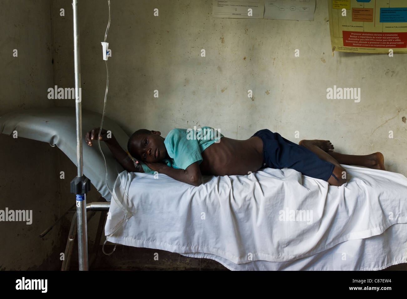 Patient avec un goutte-à-goutte intraveineux tuyau relié au dispensaire mal équipés, Quelimane Mozambique Banque D'Images