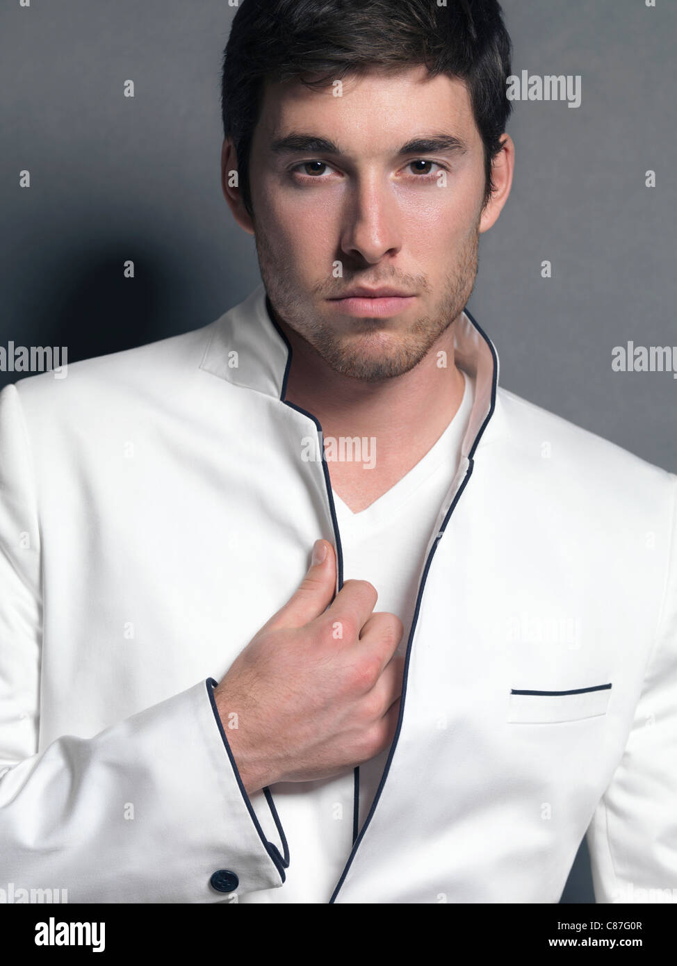 Licence et tirages sur MaximImages.com - Portrait d'un jeune homme portant un blazer blanc élégant Banque D'Images