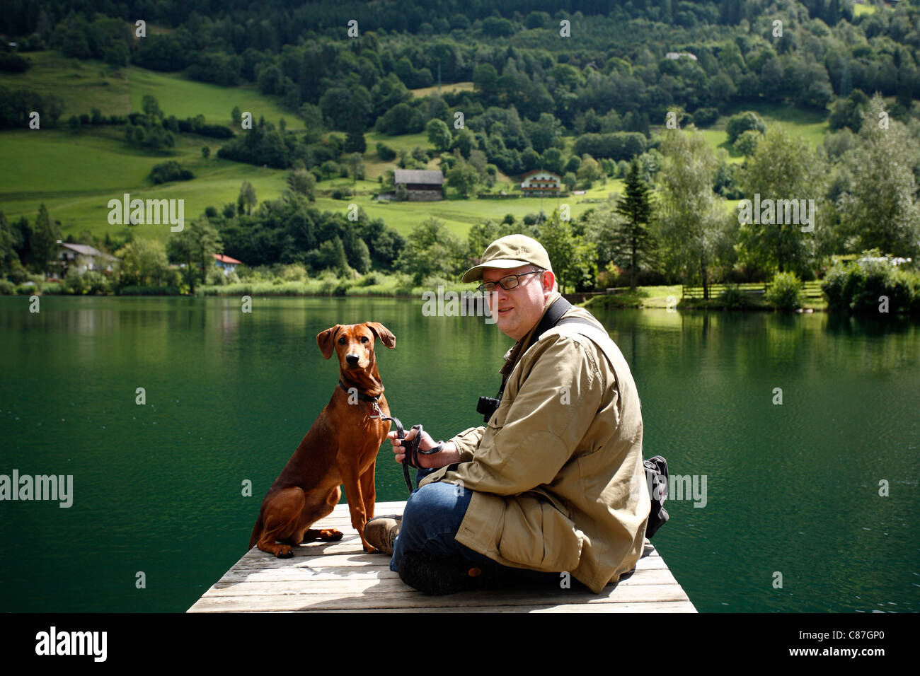 L'homme avec son chien à l'Brennsee, Feld am See, Autriche Banque D'Images