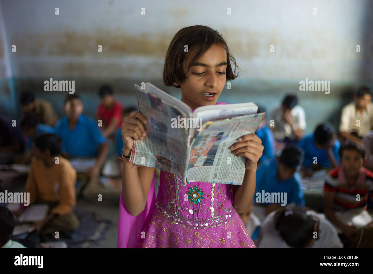 Indian girl la lecture à haute voix pendant la leçon d'anglais à l'école en Rajyakaiya Narlai village, Rajasthan, Inde du Nord Banque D'Images