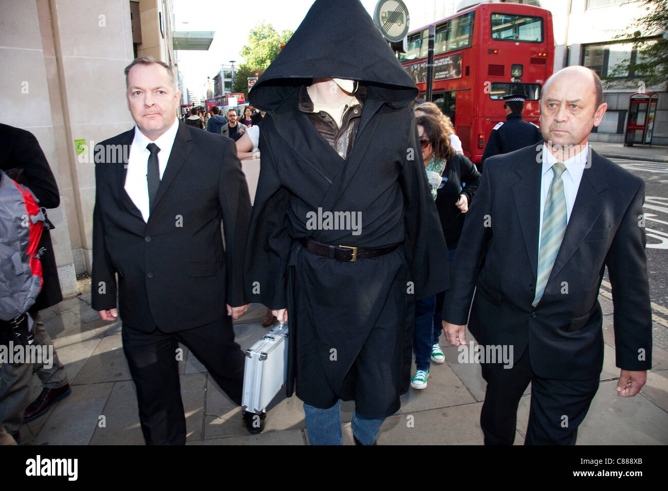 Julian Assange de WikiLeaks à la manifestation Occupy London 15 octobre 2011. Vu ici, il essaie de passer à travers les lignes de police portant une cape noire, le capot et le masque. Il a immédiatement demandé de retirer le masque où il a été traîné dans sur, interrogé et relâché. Banque D'Images