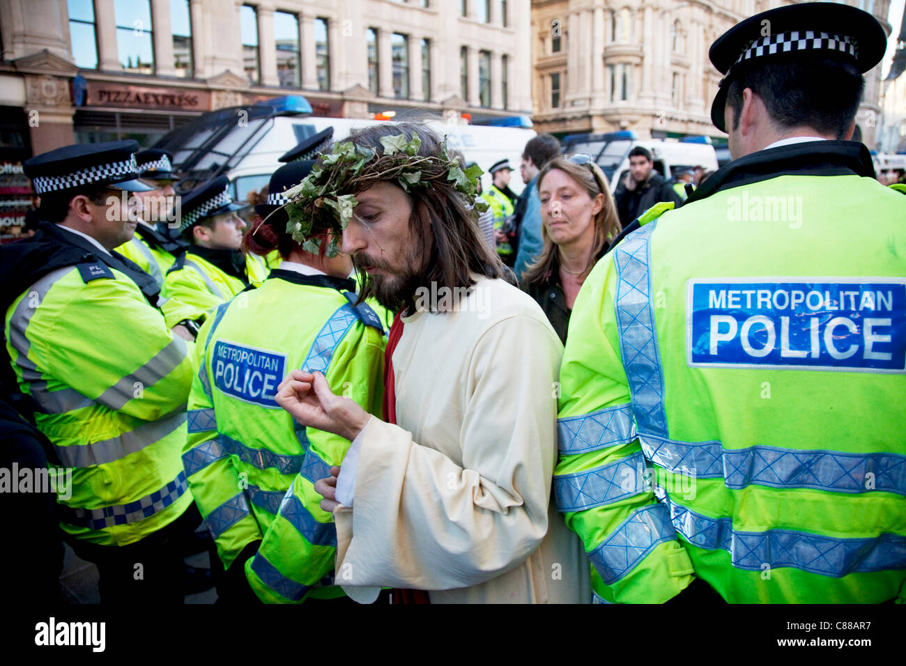 Homme habillé comme Jésus de promenades à travers les lignes de police à Occupy London protester à St Paul, le 15 octobre 2011. La protestation s'étend de nous avec cette manifestations à Londres et dans d'autres villes dans le monde entier. Le mouvement 'occuper' se propage via les médias sociaux. Banque D'Images