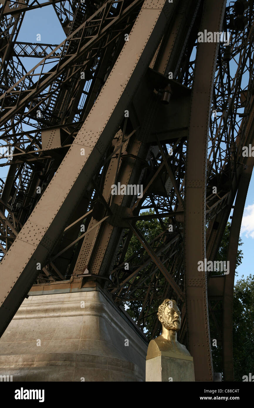 Monument à Gustave Eiffel par le sculpteur français Antoine Bourdelle à côté de l'un des piliers de la Tour Eiffel à Paris, France. Banque D'Images