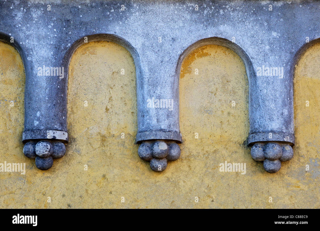 Conception d'ornements en pierre sculpté Arch contre un mur de plâtre jaune pâle de Banque D'Images