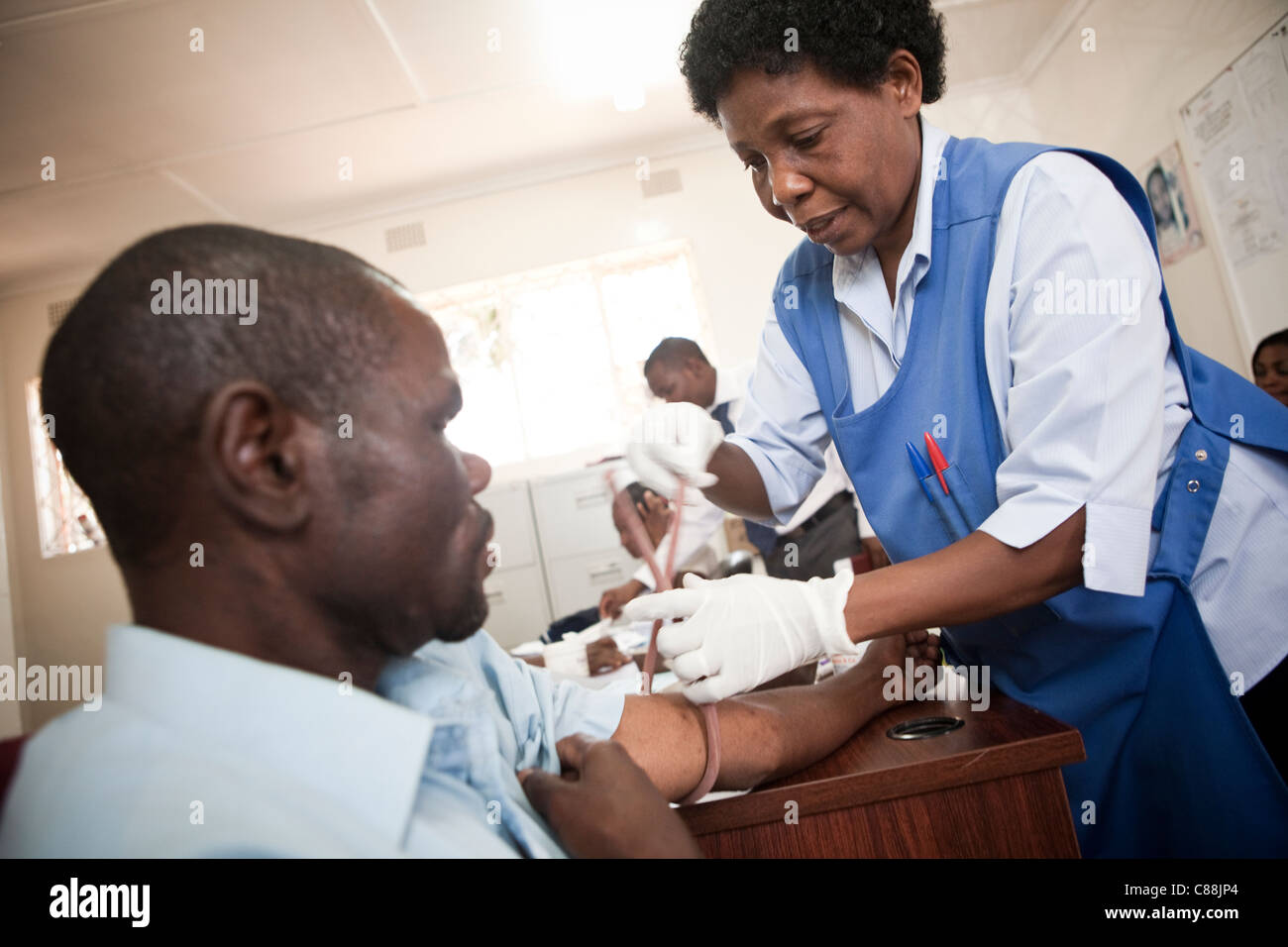 Une infirmière attire le sang d'un patient VIH-positif dans une clinique soutenue par le Secours catholique à Lusaka, Zambie. Banque D'Images