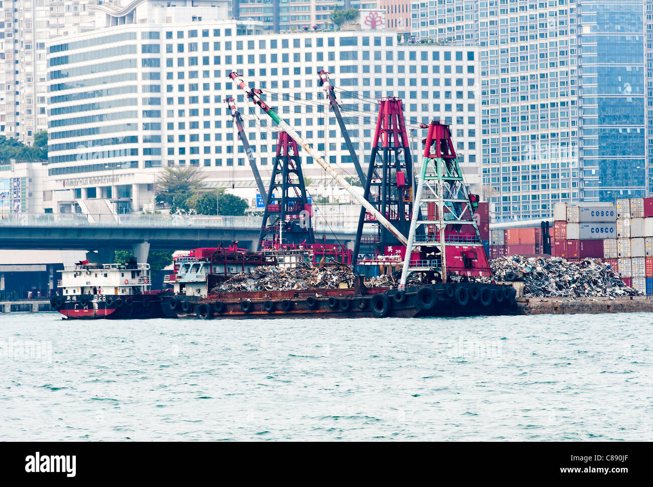 Le traitement de la ferraille sur la jetée avec chaland Barge avec grande grue à Victoria Harbour Kowloon Hong Kong Chine Asie Banque D'Images