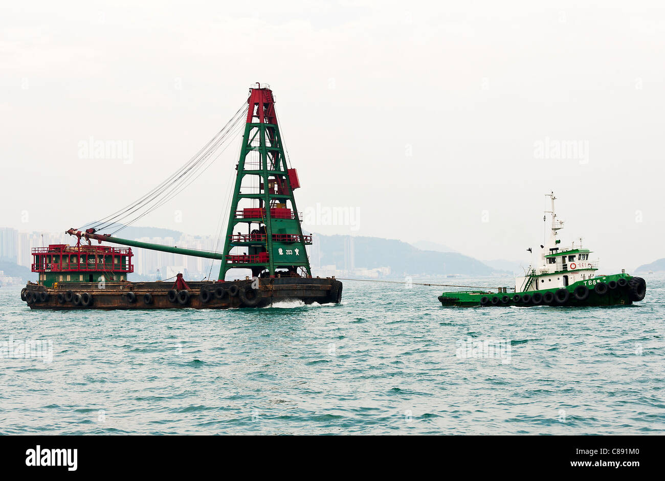 Refuser le recyclage avec grue Barge remorqué par un remorqueur à Kowloon Bay Victoria Harbour Hong Kong Chine Asie Banque D'Images
