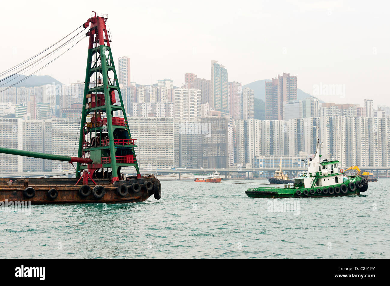 Refuser le recyclage avec grue Barge remorqué par un remorqueur à Kowloon Bay Victoria Harbour Hong Kong Chine Asie Banque D'Images