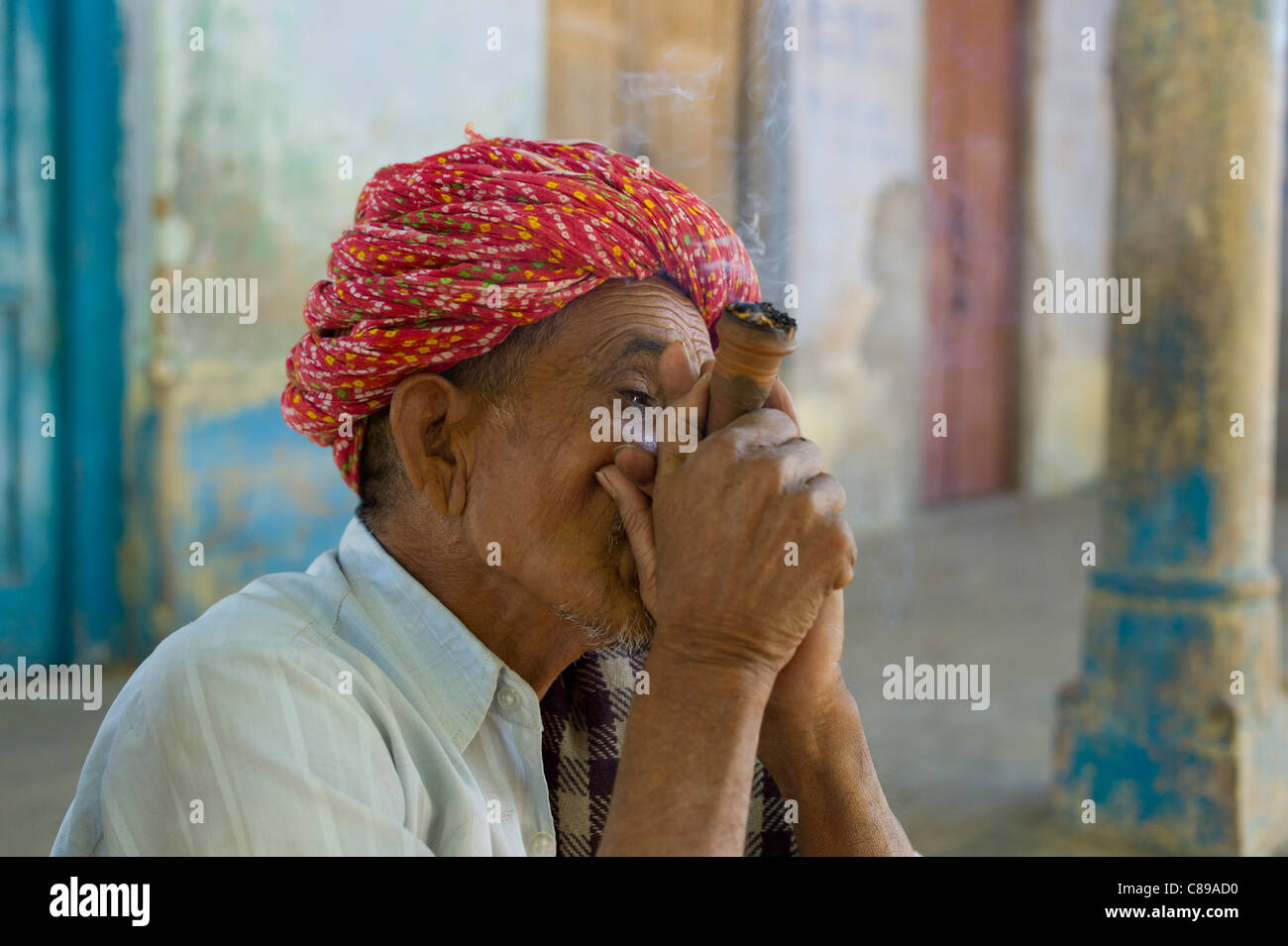 Les hommes indiens, l'un fumeur de tabac de Chillam pipe en argile, en turbans Rajasthani dans village Nimaj, Rajasthan, Inde du Nord Banque D'Images