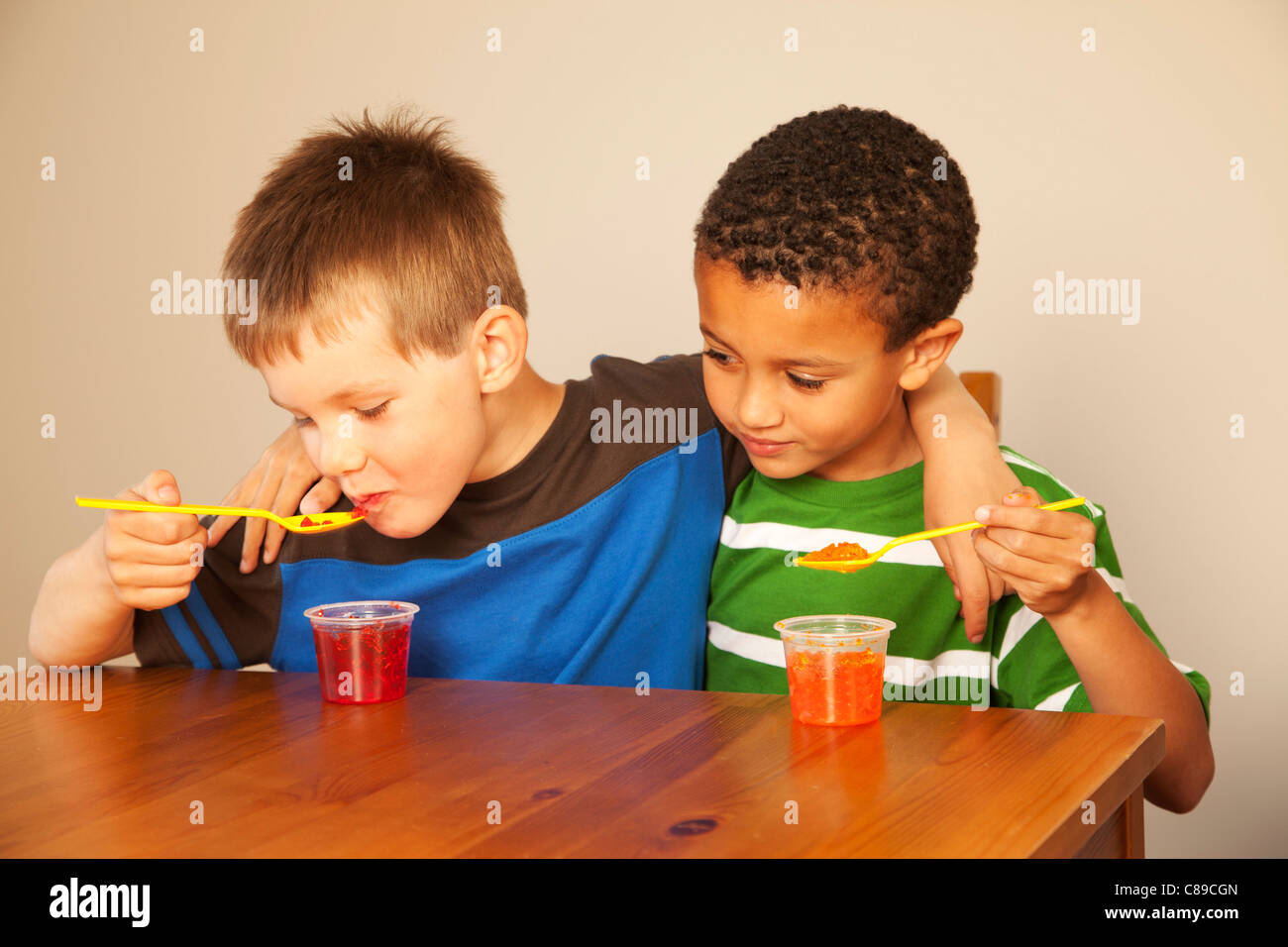 Deux garçons à une table de cuisine manger Jell-O. Banque D'Images
