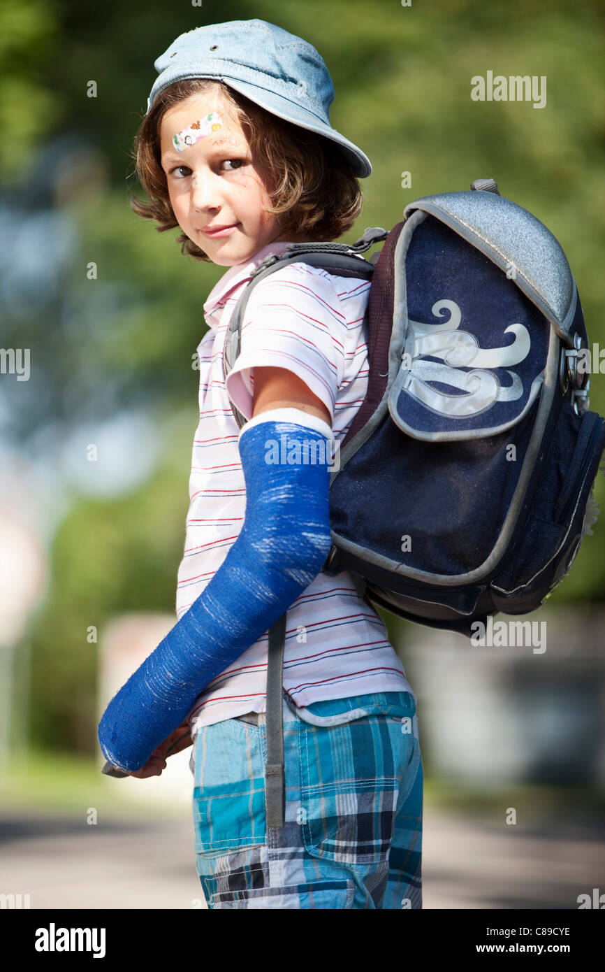 Germany, Bavaria, blessés girl avec le bras dans le plâtre sur chemin de l'école Banque D'Images