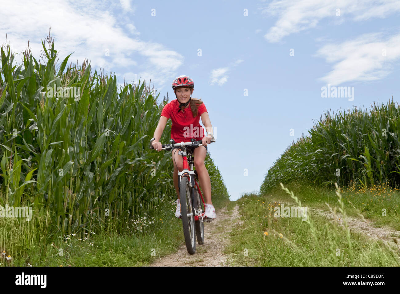 Germany, Bavaria, young woman riding mountain bike Banque D'Images