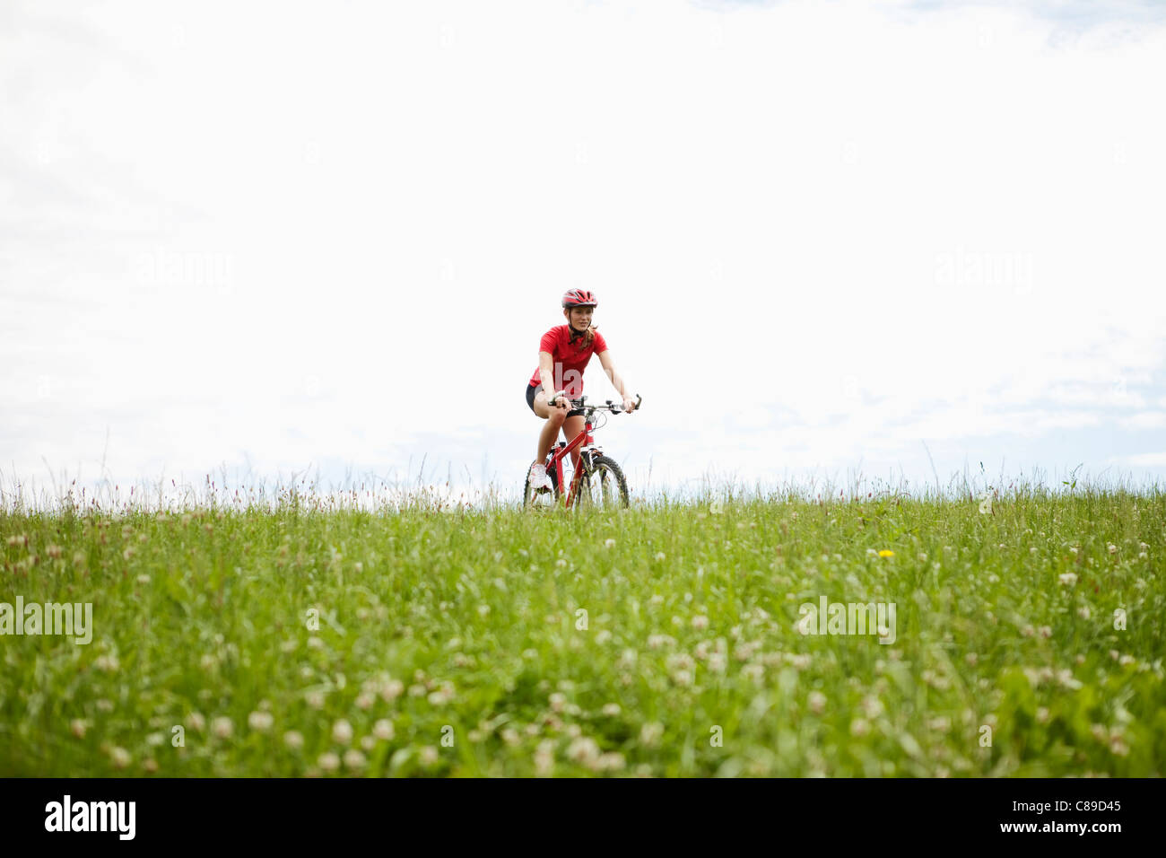 Germany, Bavaria, young woman riding mountain bike Banque D'Images