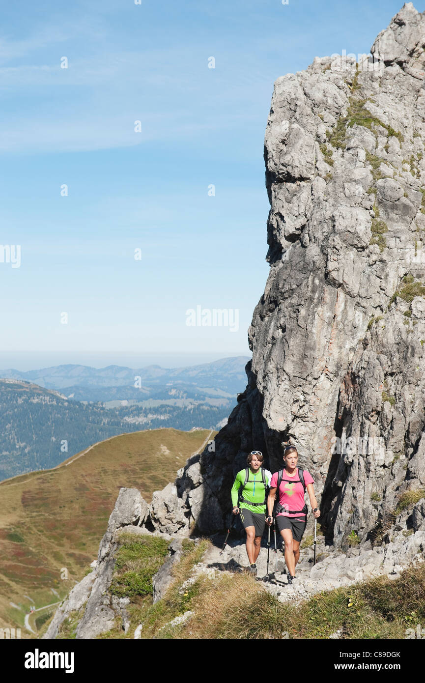 L'Autriche, Kleinwalsertal, l'homme et la femme la randonnée à proximité de rochers en montagne Banque D'Images