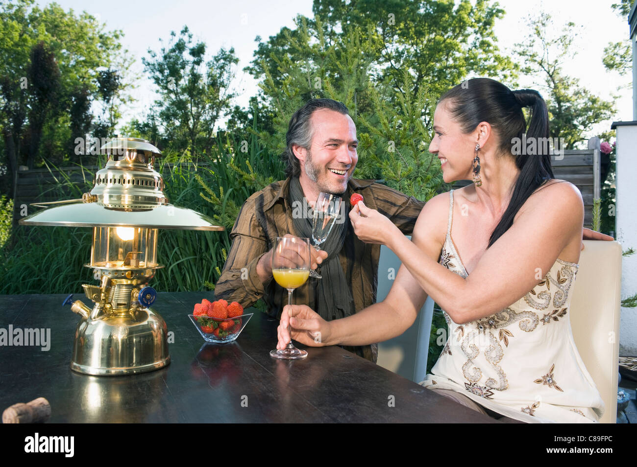 Germany, Bavaria, Couple enjoying drinks avec lanterne en premier plan Banque D'Images