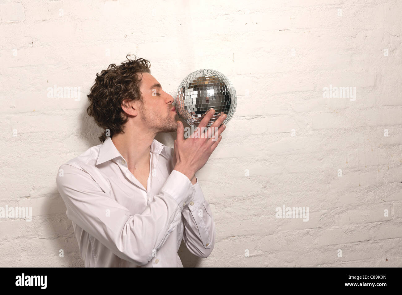 Allemagne, Hambourg, Mid adult man kissing mirror ball Banque D'Images