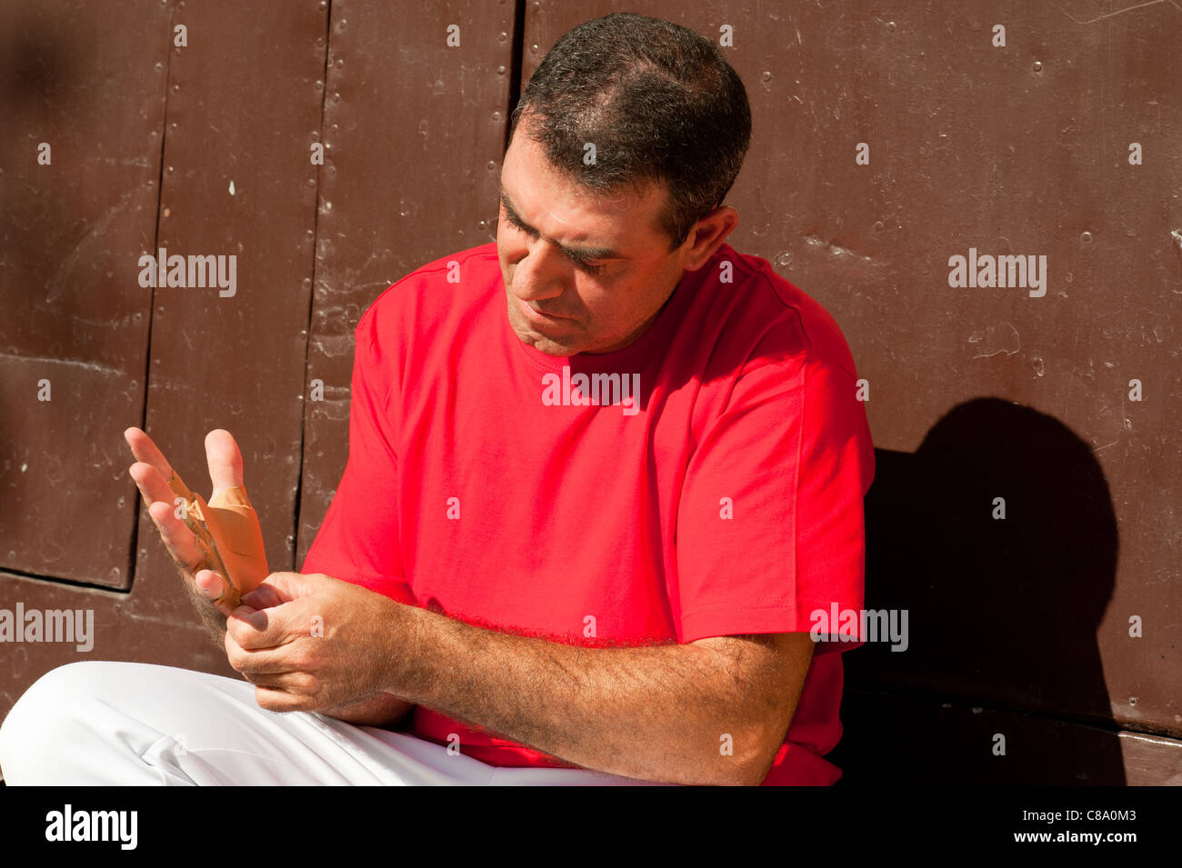 Joueur de pelote basque espagnol traditionnel rituellement enroulant ses doigts dans les protections de plâtre Banque D'Images