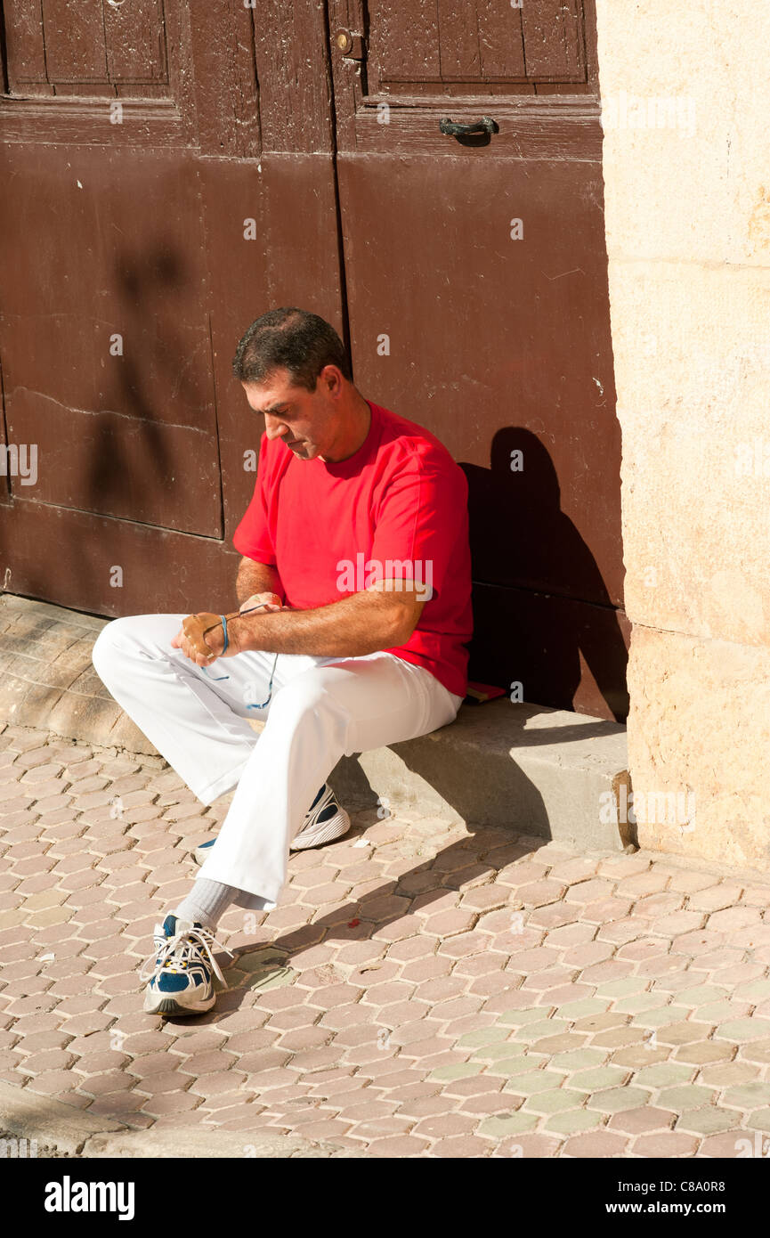 Joueur de pelote basque espagnol traditionnel rituellement enroulant ses doigts dans les protections de plâtre Banque D'Images