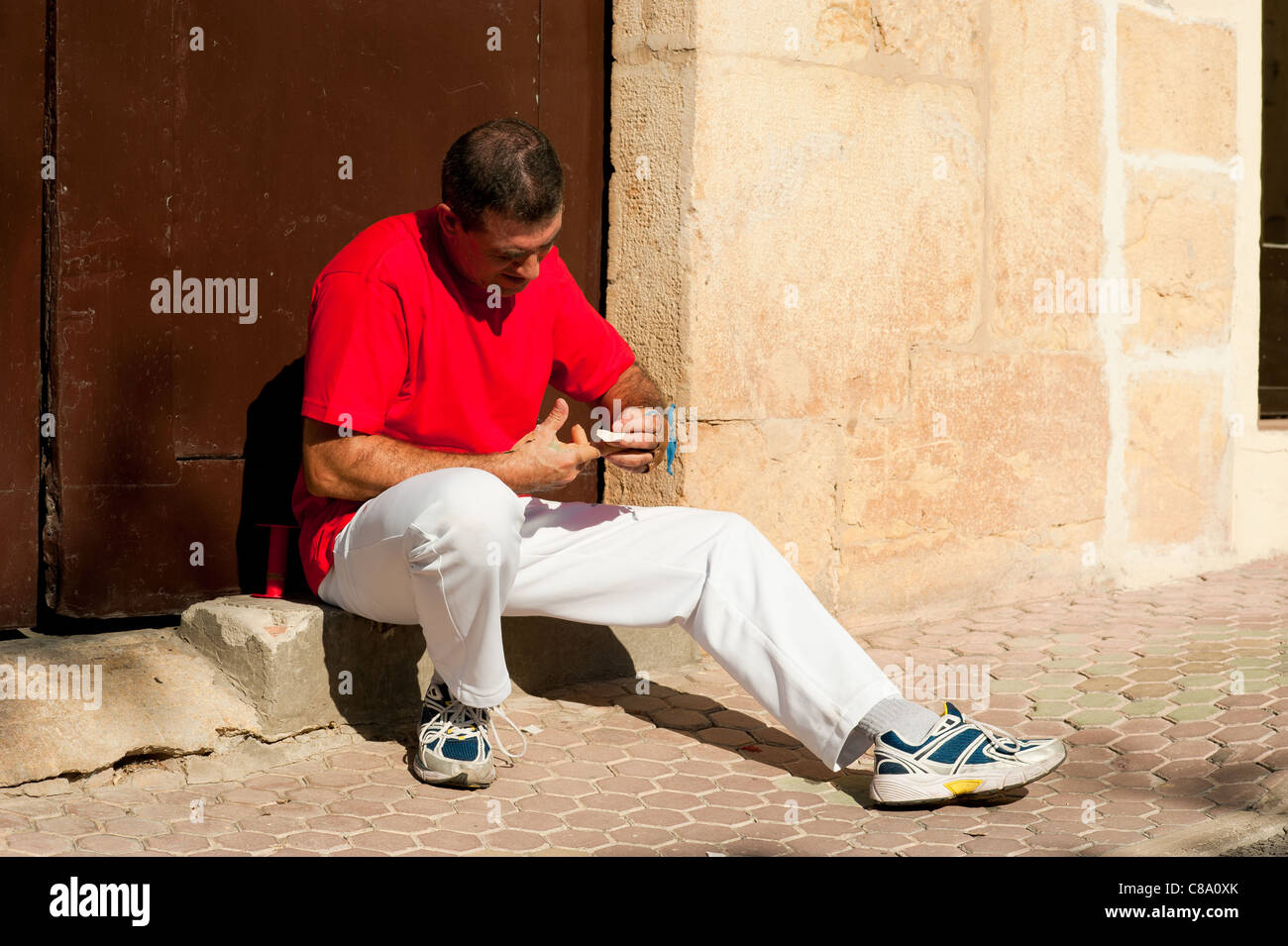 Joueur de pelote basque espagnol traditionnel rituellement enroulant ses doigts dans les protections de plâtre Banque D'Images