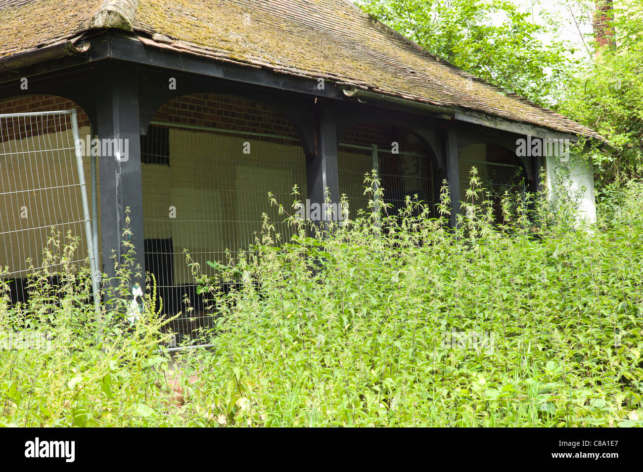 Bâtiment délabré avec clôture de fer autour de park Banque D'Images